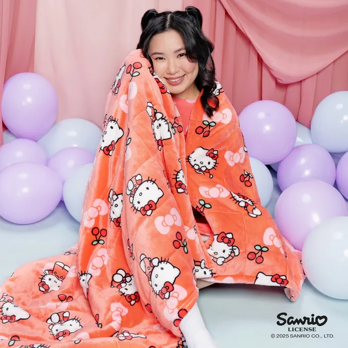 Hello Kitty Sherpa Blanket held up in front of pastel balloons