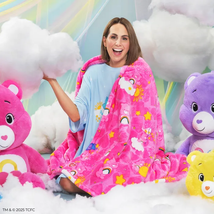 Care Bears™ Sherpa Blanket, pink, wrapped around a smiling woman